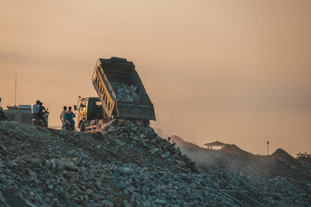 Garbage truck dumping load in a landfill