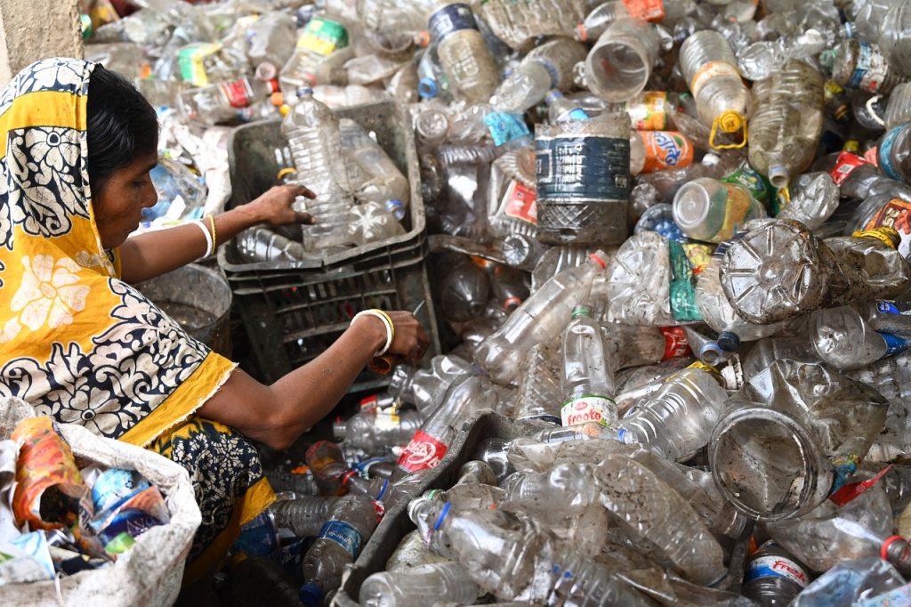 Indian woman working at a landfill with plastic bottles
