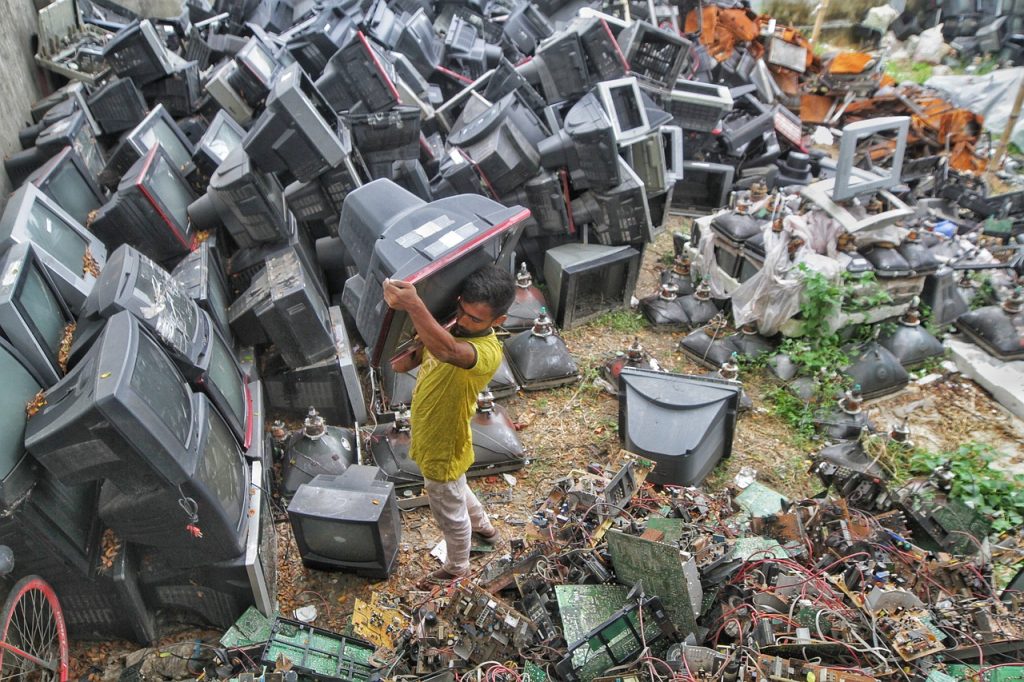 Man in a field of electronic waste recycling electronics