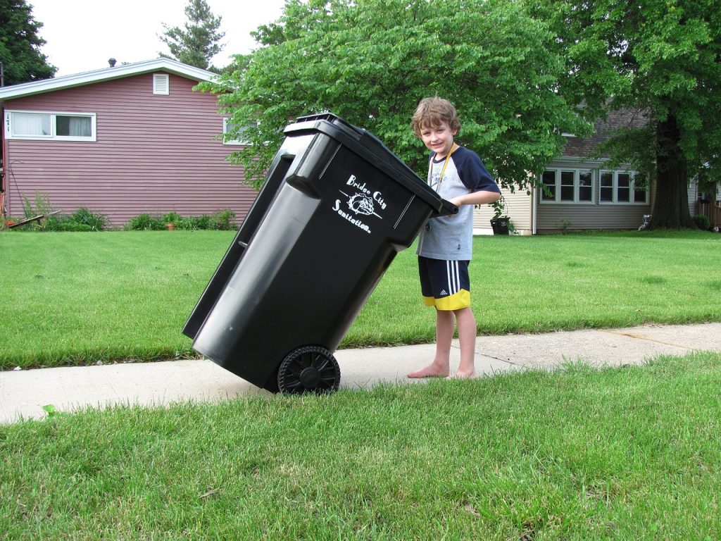 Kid with a rolling garbage bin